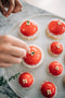 adding fresh lemon thyme sprigs on top of strawberry tart made fresh by tartlet bakery