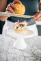 grating orange zest over a white chocolate and orange mascarpone tart made fresh by tartlet bakery